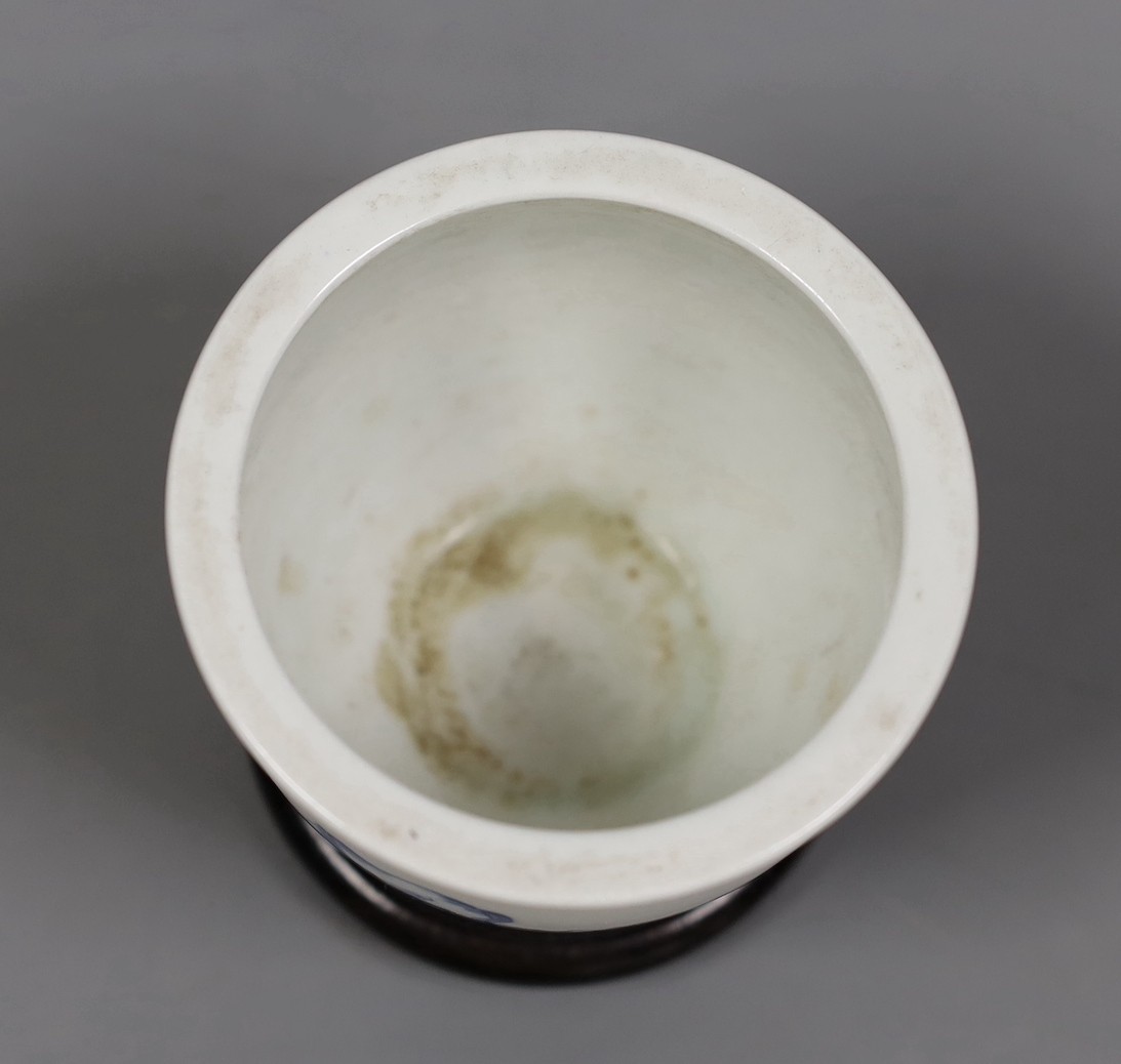 A Chinese blue and white ‘eight horses’ brush pot, on wooden stand, 8cm tall including stand